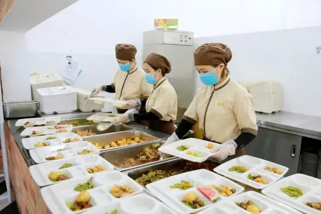Nhân viên LG Food chia suất ăn vào khay tại bếp