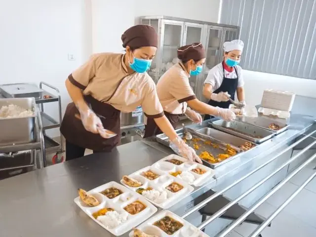 Nhân viên LG Food chia suất ăn tại quầy của trường